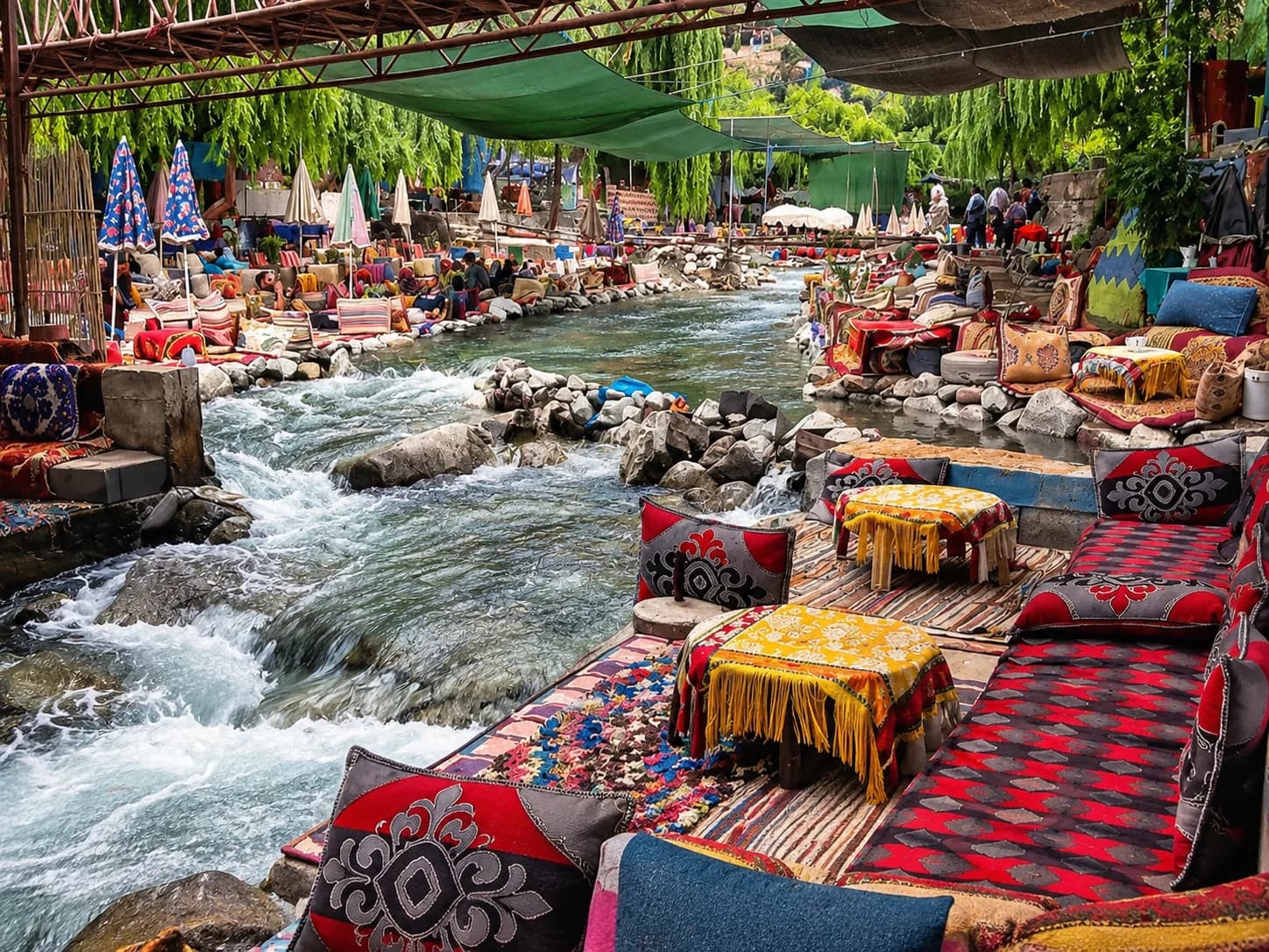 Tables basses et coussins installés au bord de la rivière dans une vallée de l’Atlas